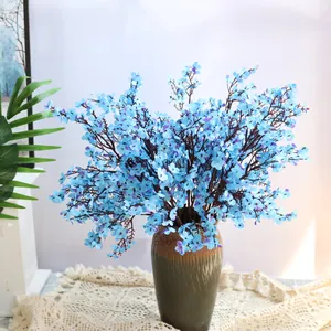 Vista detallada de flores artificiales de gipsofila de seda azul en jarrón rústico
