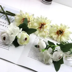 Detailed macro view of artificial white roses and creamy yellow gerberas on an open magazine