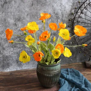 Vista detallada de flores artificiales de amapola de Islandia en seda amarilla y naranja