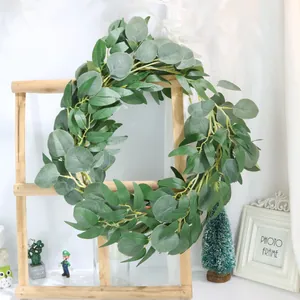 Detail view of a realistic green eucalyptus and willow leaf wreath on a wooden frame ladder