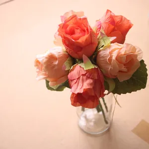 Detailaufnahme eines künstlichen Seidenrosenstraußes mit leuchtend orangefarbenen Blüten