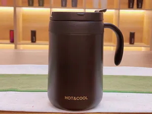 Close-up view of a matte black stainless steel insulated mug featuring a handle and lid