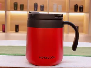 Macro view of a red 304 stainless steel insulated coffee mug with a black handle.