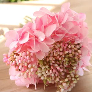 Close-up detail of soft pink silk hydrangea petals with small artificial berry clusters