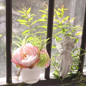 Close-up of artificial pink peony potted plant decoration on a bright sunny windowsill