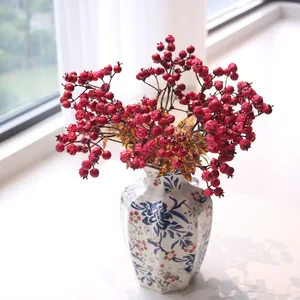 Detailed macro shot of realistic red artificial pomegranate berries in a blue vase