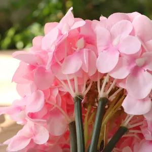 Detailed macro shot of pink silk hydrangea petals and green stems for home decor.