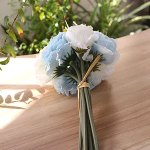 Detailed view of light blue and white artificial hydrangea carnation bouquet on wood