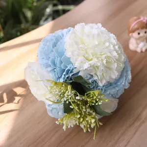 Close-up of blue and white artificial hydrangea carnation bouquet on wooden table