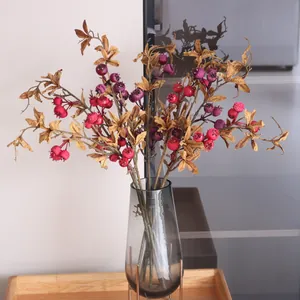 Artificial pomegranate fruit branch in glass vase for elegant home decor