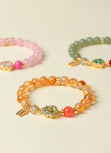 Detaillierte Ansicht von handgefertigten Perlenarmbändern mit Citrin und Glücksbringern.