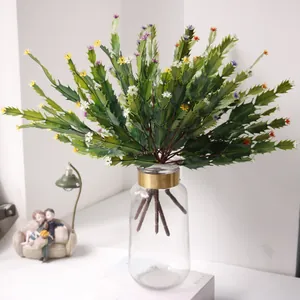 Detailed view of vibrant artificial cactus with colorful small flowers in glass vase