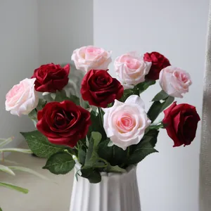 Close-up detail of realistic red and pink silk roses in a white elegant fluted vase