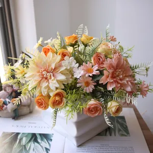 Close-up of artificial dahlia and rose bouquet in a white ceramic vase on a desk