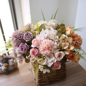Detailansicht eines künstlichen Rosen- und Chrysanthemenstraußes in einem Weidenkorb