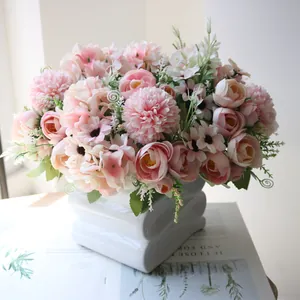 Close-up detail of artificial pink tea rose and hydrangea bouquet in white ceramic vase