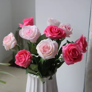 Detailed view of realistic pink and magenta silk artificial roses in a white vase