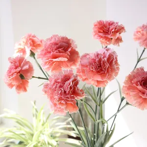 Vue détaillée d'œillets en soie réalistes avec des pétales rose tendre et doux.