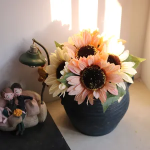 Close-up of realistic artificial 6-head sunflowers in a vintage pot under warm sun rays