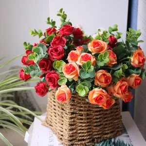Close-up detail of a colorful artificial rose bouquet with eucalyptus in a woven basket.