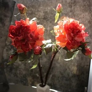 Detailed view of luxury artificial silk peony flowers with realistic red petals.