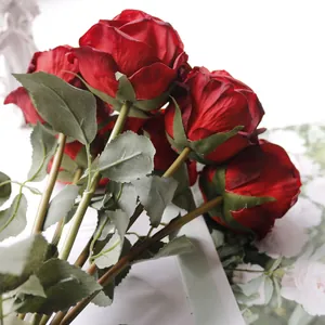 Nahaufnahme künstlicher roter Rosen mit Brandkante für Wohndekoration