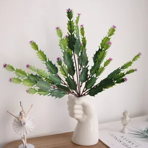 Close-up of artificial cactus plant inside creative fist-shaped white ceramic vase