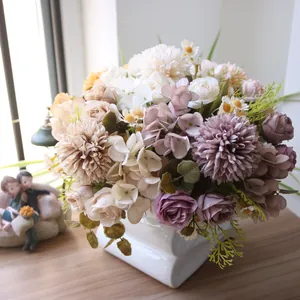 Nahaufnahme eines herbstlichen Seidenchrysanthemen- und Rosenstraußes in weißer Vase