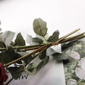 Detailansicht der Stängel und Blätter eines künstlichen Rosenstraußes mit französischen Rändern