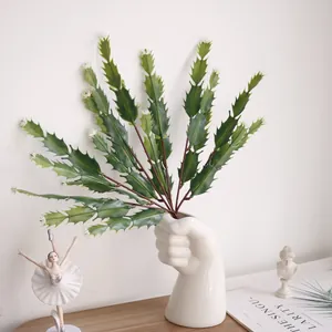 Detail view of artificial cactus plant in creative white fist vase for home decor