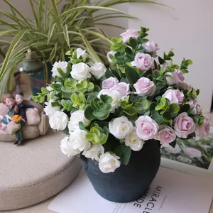 Close-up of artificial pink and white rose bouquet with eucalyptus in a dark ceramic vase