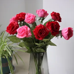 Detailed view of realistic red and pink silk roses in a decorative glass vase.