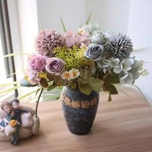 Detailaufnahme von Herbst-Kunstblumenstrauß mit Rosen und Kamille in Vintage-Vase