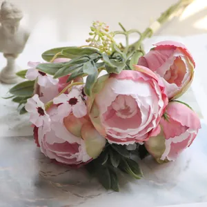 Detailansicht von künstlichen rosa Seidenpfingstrosen und grünen Blättern im Brautstrauß