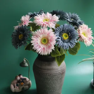 Beautiful artificial pink and blue gerbera daisy flowers in a grey vase for home decoration