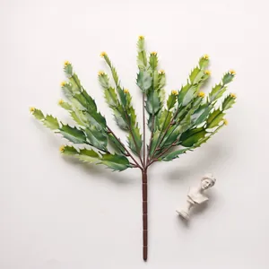 Detailed close-up of artificial cactus branch with green leaves and yellow buds