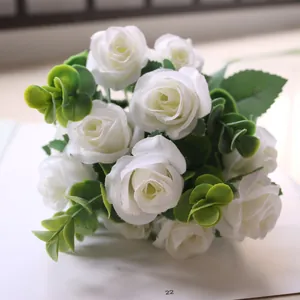 Close-up of white artificial rose bouquet featuring realistic eucalyptus leaves