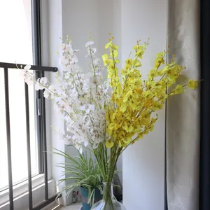 A beautiful macro detail view of yellow and white artificial dancing lady orchids in a vase
