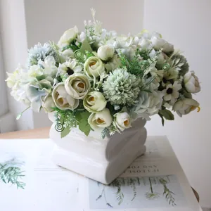 Detailed view of artificial green tea buds and hydrangeas in a white ceramic vase.