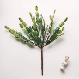 Detailed view of artificial green succulent branch with purple tips on white backdrop