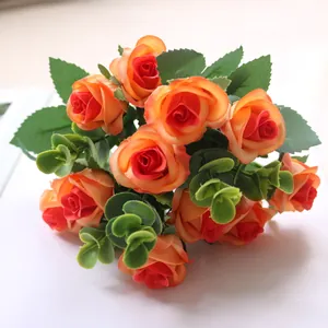Close-up of artificial orange rose bouquet with eucalyptus leaves