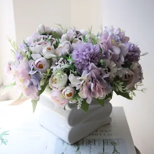 Detailed view of artificial lilac hydrangeas and pink tea buds in a white vase