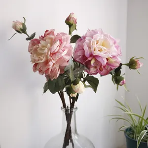 Elegant pink silk peony flower arrangement in a clear glass vase for home decoration