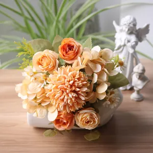 Detailaufnahme von herbstlichem Strauß aus orangefarbenen Seidenrosen und Chrysanthemen