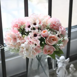 Close-up of pink artificial tea bud and daisy bouquet in a glass vase for home decor.