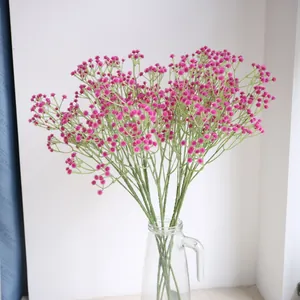 Nahaufnahme künstlicher, leuchtend rosa Schleierkrautblumen in einer Klarglasvase