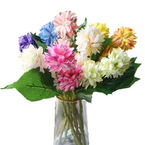 Colorful artificial pompon mums in a glass vase for home decoration