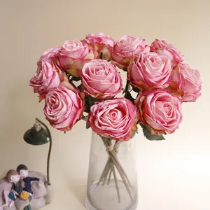 Elegante künstliche rosa Lychee-Rosen mit gebrannten Kanten in einer Glasvase.