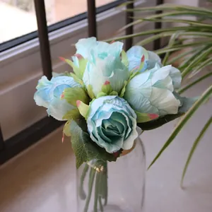 Detailed view of artificial light blue roses in a clear glass vase for decoration