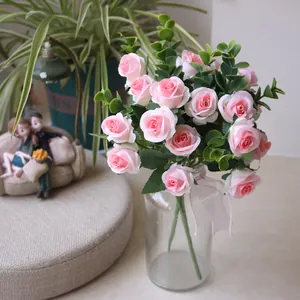 Detailed macro view of pink artificial rose bouquet with eucalyptus leaves in a glass vase